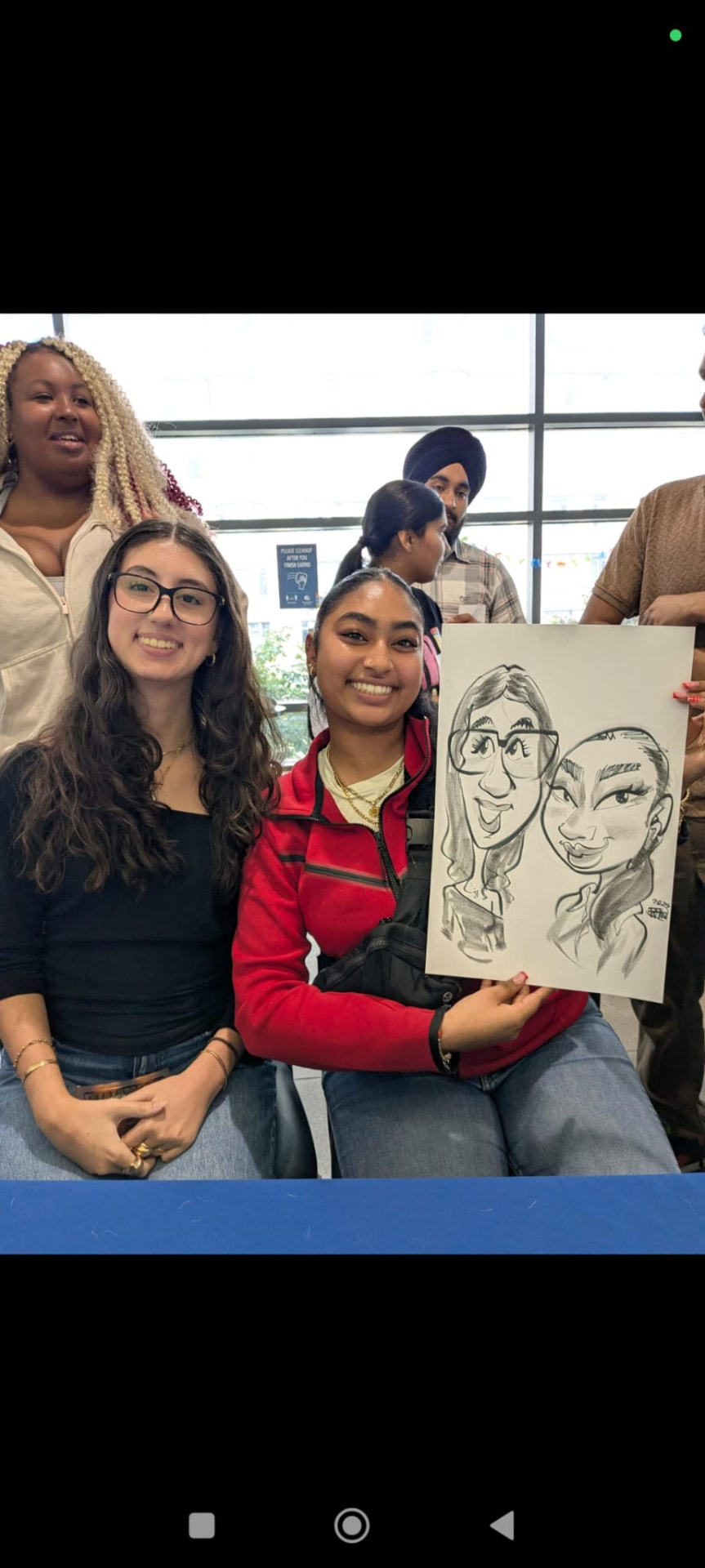 Guests smiling with their finished caricature at a campus event