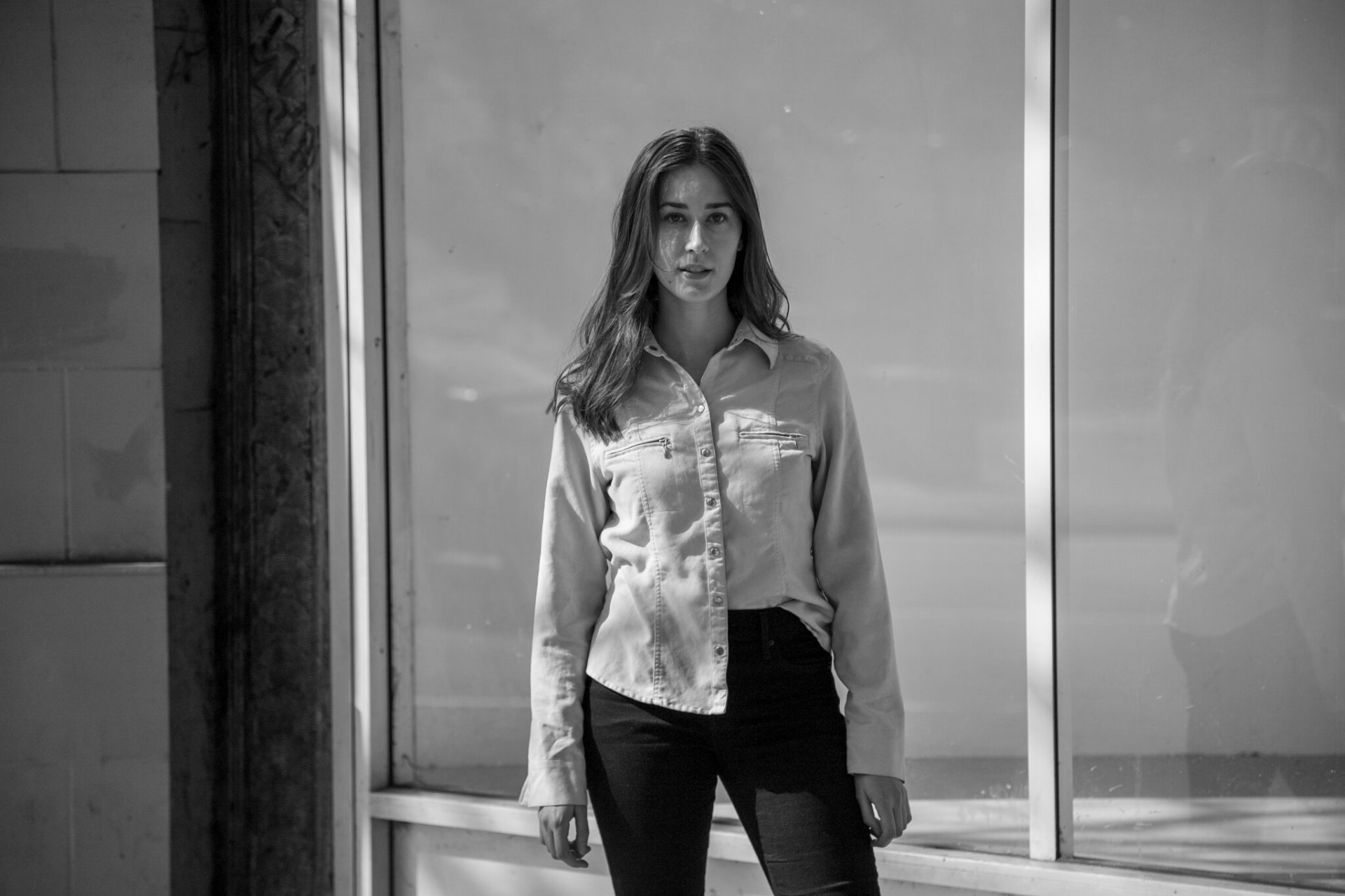 Storefront glass — full-length street portrait